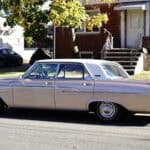 Vintage beige sedan parked on residential street
