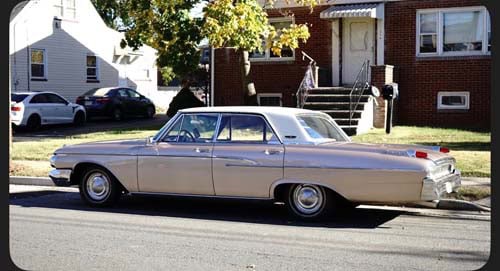 Vintage beige sedan parked on residential street