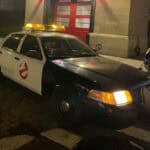 Ghostbusters-themed police car parked at night with lights