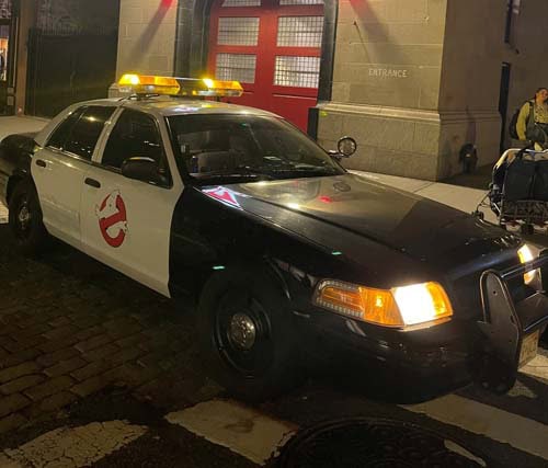 Ghostbusters-themed police car parked at night with lights
