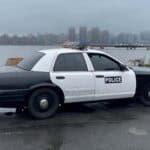 Black and white police car by waterfront skyline
