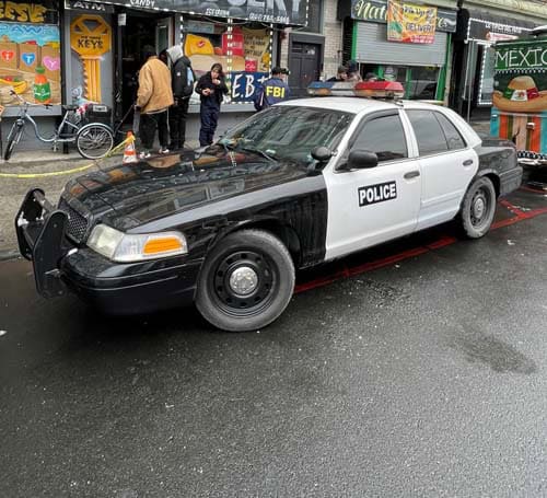 Black and white police car parked on city street