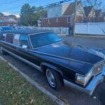 Black stretch limousine parked on residential street
