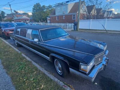 Black stretch limousine parked on residential street