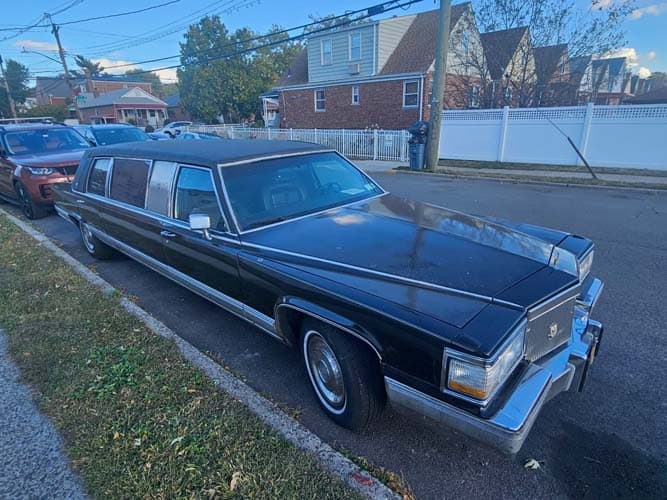 Black stretch limousine parked on residential street