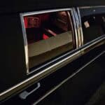 Open hearse door revealing red-lit interior