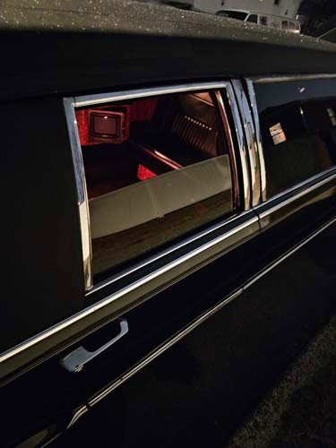 Open hearse door revealing red-lit interior