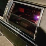Black limousine with red-lit interior through window