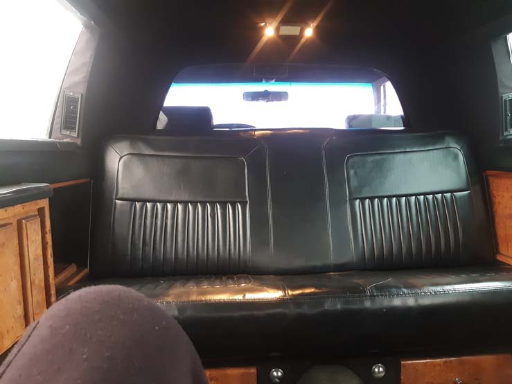 Black leather rear bench seat inside limousine interior