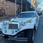 White vintage-style limousine parked on city street