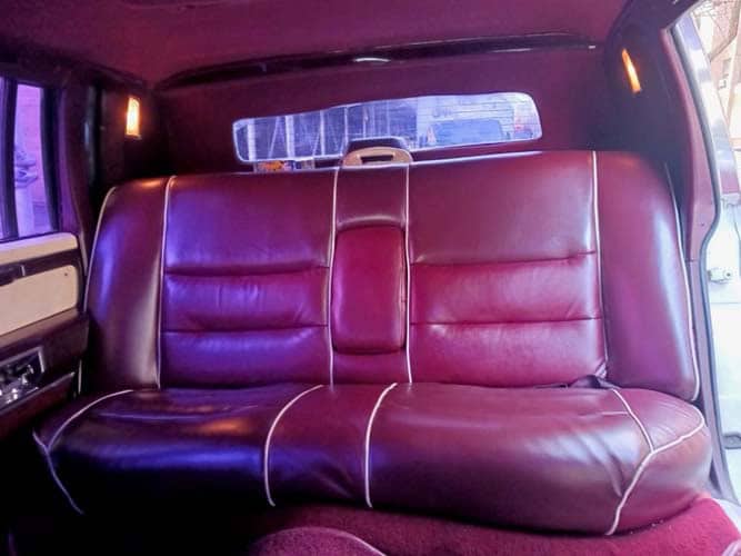 Burgundy leather backseat inside vintage car interior