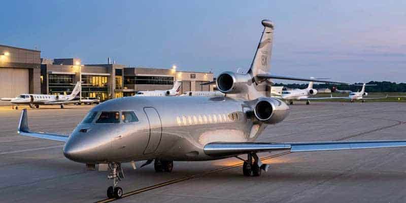 Private jet parked on airport tarmac at dusk