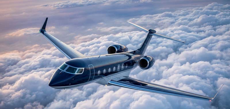 Private jet flying above clouds at sunset