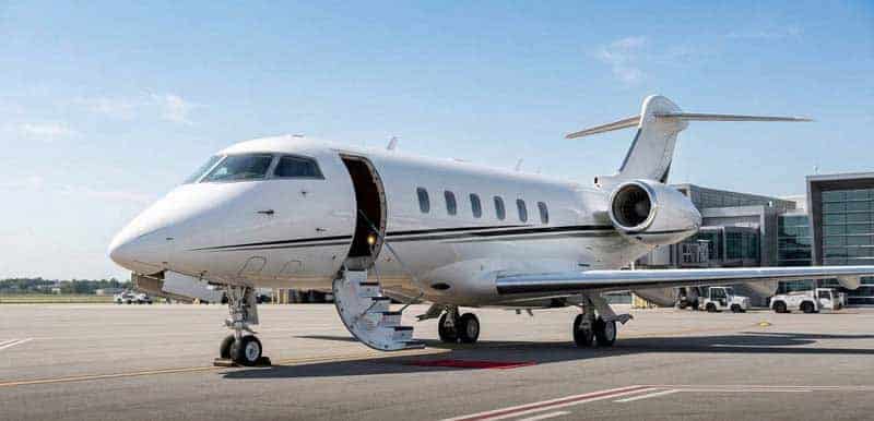 Private jet parked on runway with stairs down