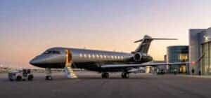 Private jet parked on airport tarmac at sunset