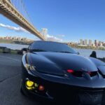 Black sports car under suspension bridge skyline