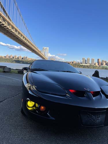 Black sports car under suspension bridge skyline
