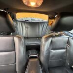 Interior of car with black leather seats and overhead light.