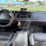 Ford car interior dashboard with steering wheel and street view.