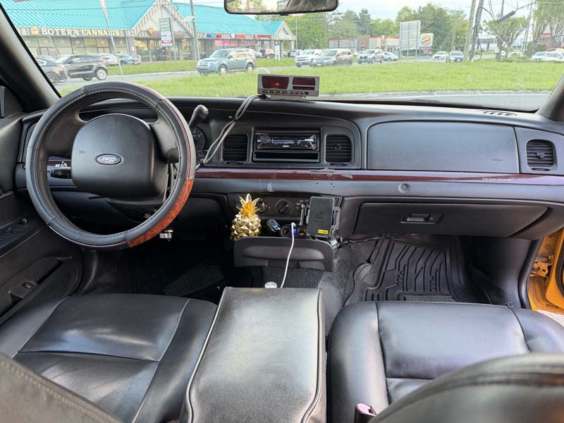 Ford car interior dashboard with steering wheel and street view.
