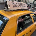 NYC taxi with 'Dean Henderson James Trafford' roof sign.