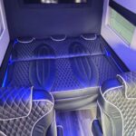 Luxury van interior with quilted seats and NVIDIA display.