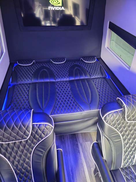 Luxury van interior with quilted seats and NVIDIA display.