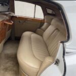Luxurious vintage car back seat with tan leather upholstery.