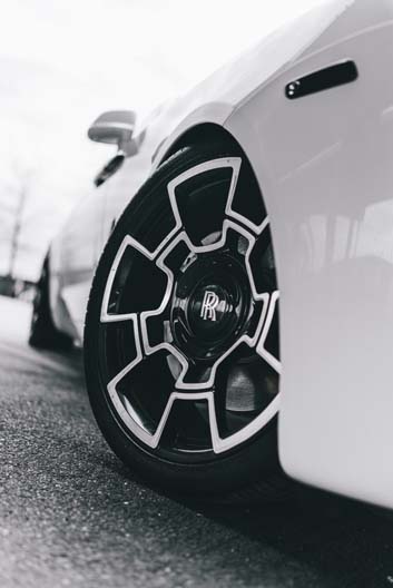 Close-up of a white Rolls-Royce wheel with geometric rim.