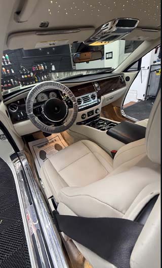 Luxurious Rolls-Royce car interior with cream leather and starlight roof.