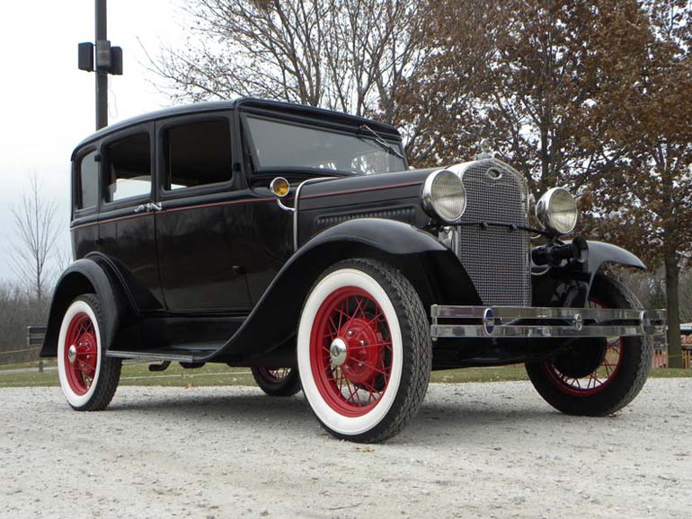 Vintage black car with red wheels and whitewalls