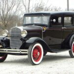 Vintage black 1930s sedan with red wheels