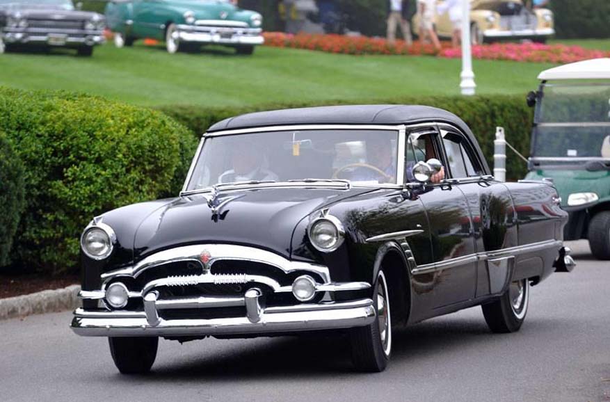 Black vintage 1950s sedan driving on street