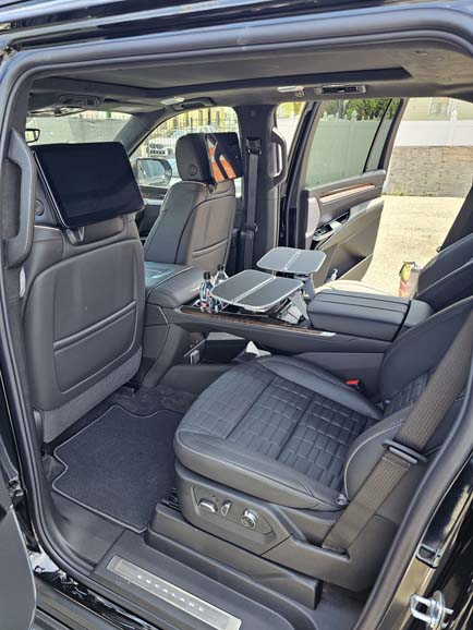 Luxury SUV interior with rear screens and tray tables