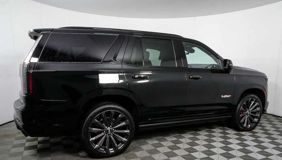 Black full-size SUV in showroom side view