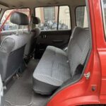 Red vehicle rear interior with striped bench seat