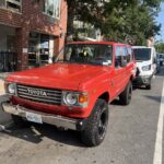 Red vintage Toyota SUV parked on a city street