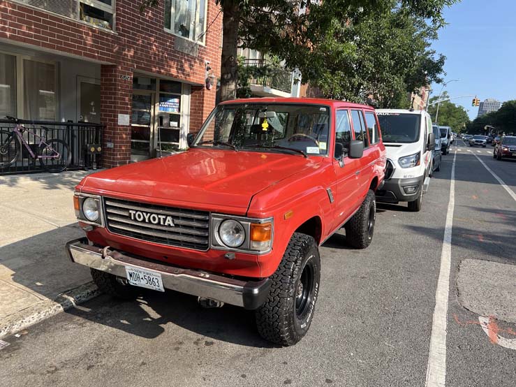 Red vintage Toyota SUV parked on a city street