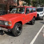 Red vintage Toyota SUV parked on city street