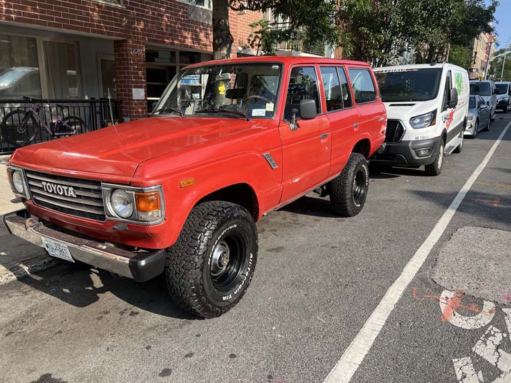 Red vintage Toyota SUV parked on city street