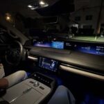 Illuminated luxury car interior with digital dashboard at night