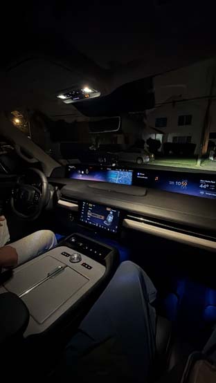 Illuminated luxury car interior with digital dashboard at night
