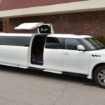 White stretch limousine with raised gullwing door parked outside