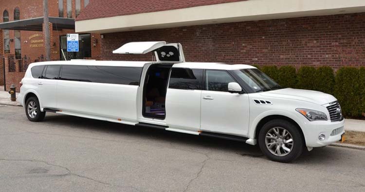 White stretch limousine with raised gullwing door parked outside