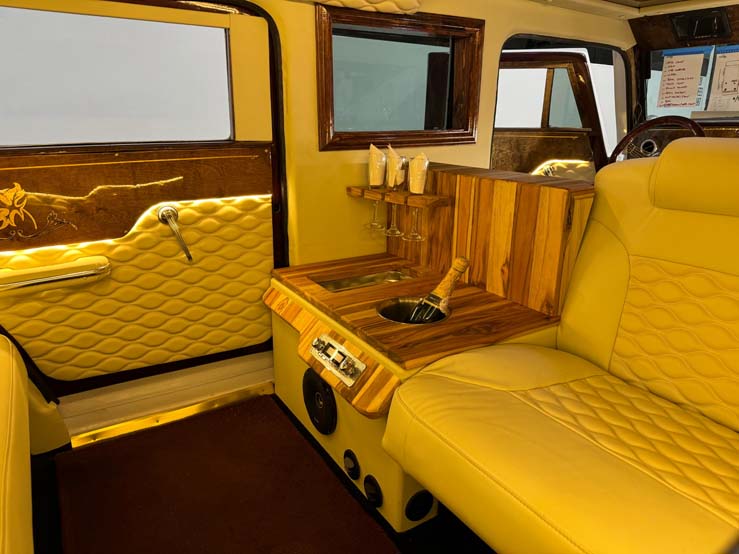 Luxury yellow leather limousine interior with wooden champagne bar