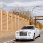 White luxury sedan driving on a city road