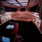 Luxury limousine interior with leather seating, bar, and touchscreen controls