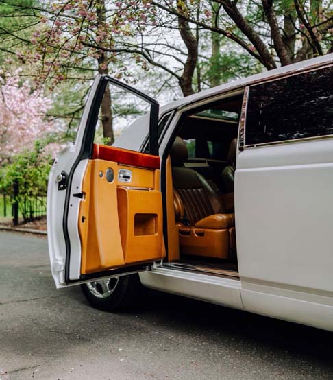 White luxury car with open door and tan interior